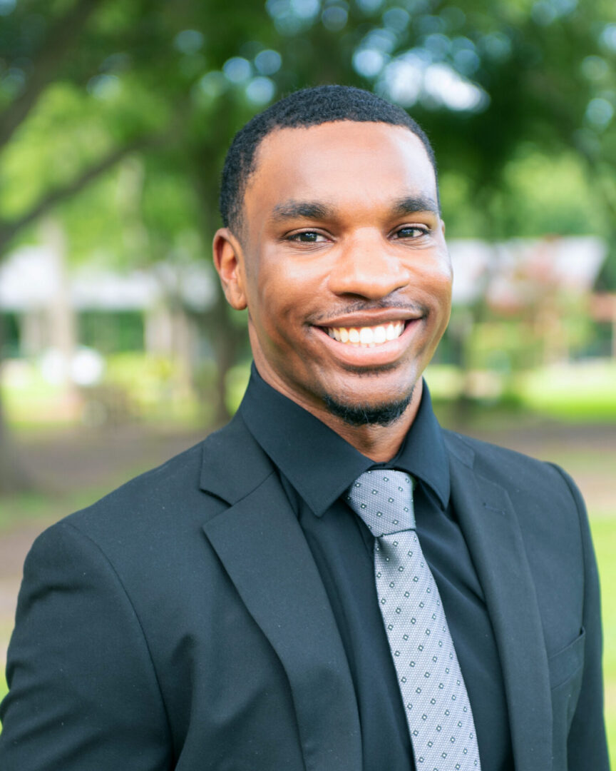 Young man standing in park wearing business suit